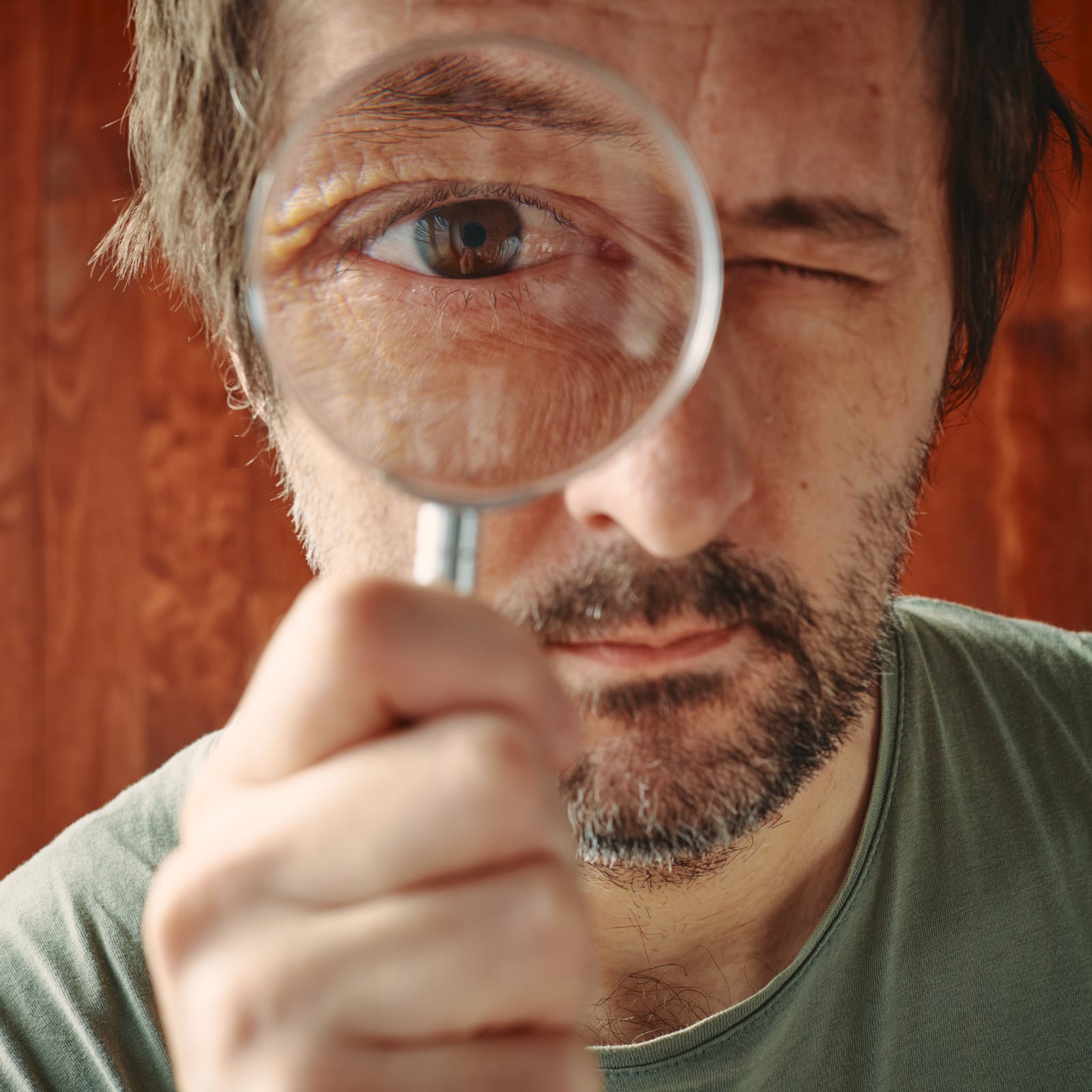 Close-up of a person inspecting a website through a magnifying glass — visual metaphor for forensic UX analysis